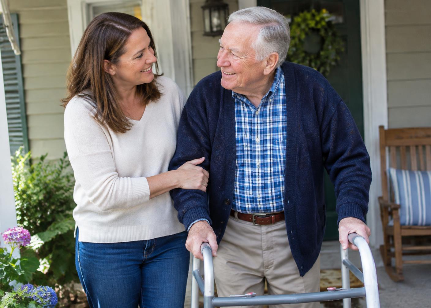 Adult daughter walking with her senior father on a front porch